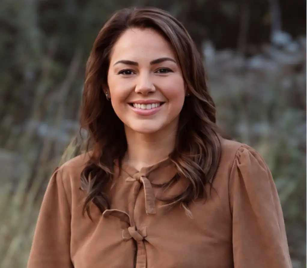 Woman in a shirt at the camera with a blurred background